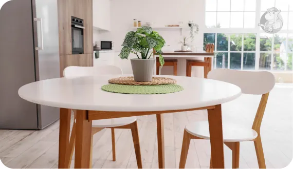 Biały okrągły stół z dwoma krzesła jako sposób na strefę jadalnianą w kuchni